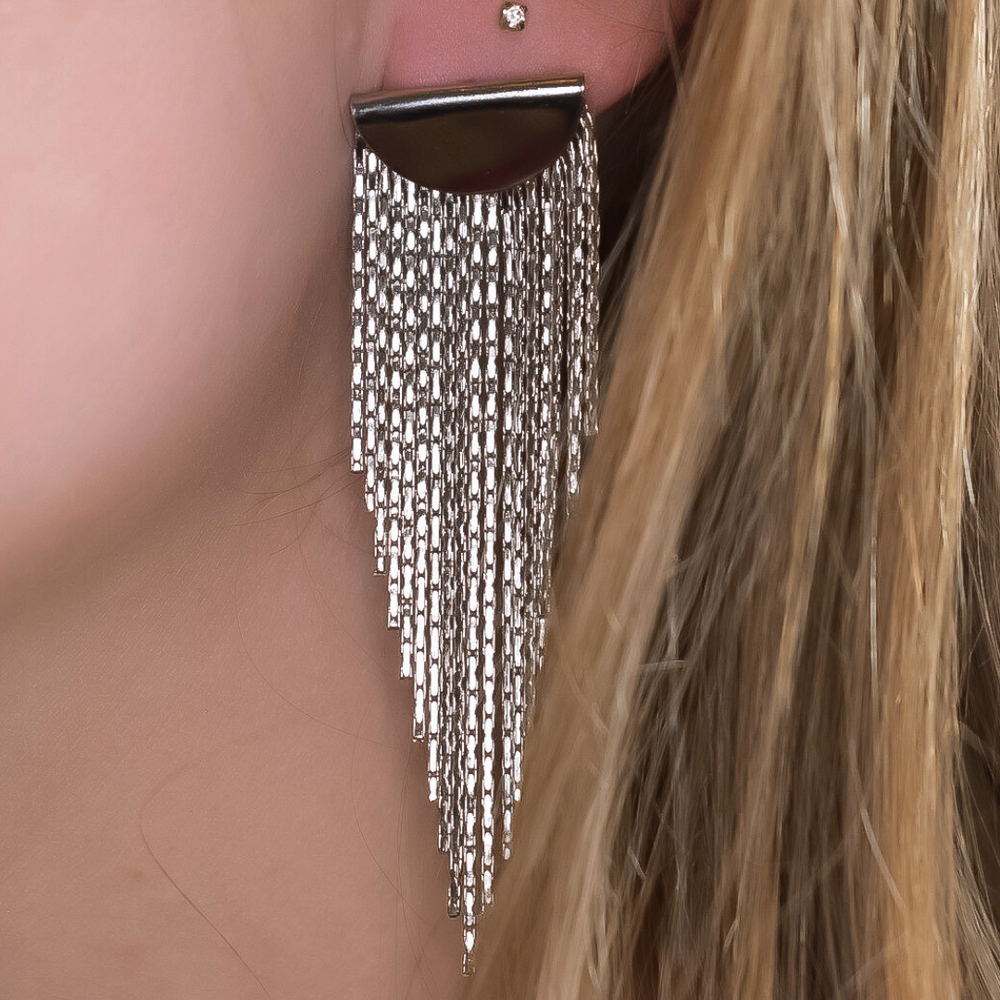Close-up van de Golden Fringe oorbellen, met een gouden plaatje en lange franjes in verschillende lengtes die in een punt lopen, gemaakt van stainless steel, waterproof, hypoallergeen en verkleuren niet.