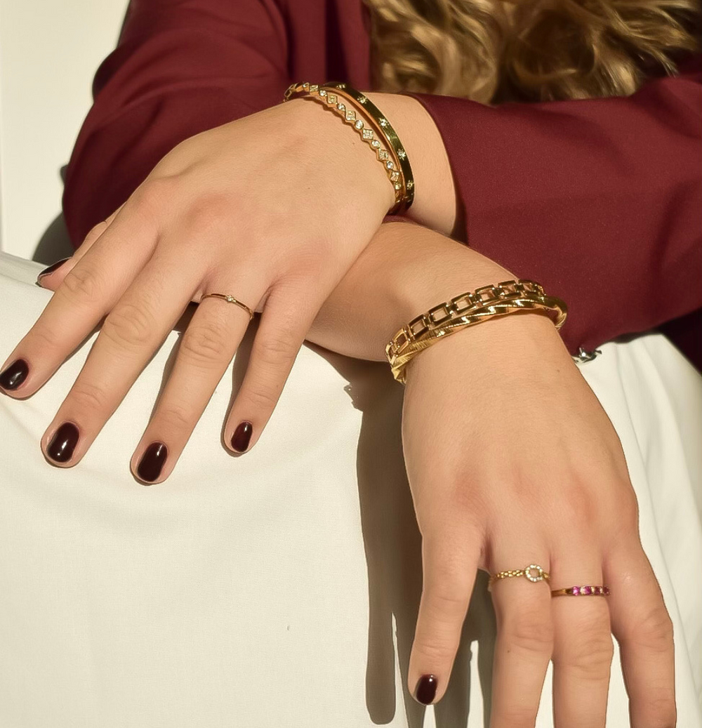 Een fijne, minimalistische gouden ring met een subtiel zilveren steentje, gemaakt van hypoallergeen, waterproof en kleurvast stainless steel.