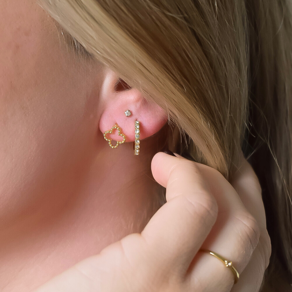 Close-up van de Clover oorbellen, kleine stainless steel knopjes met een klavertje vier design, hypoallergeen, waterdicht en verkleuren niet.