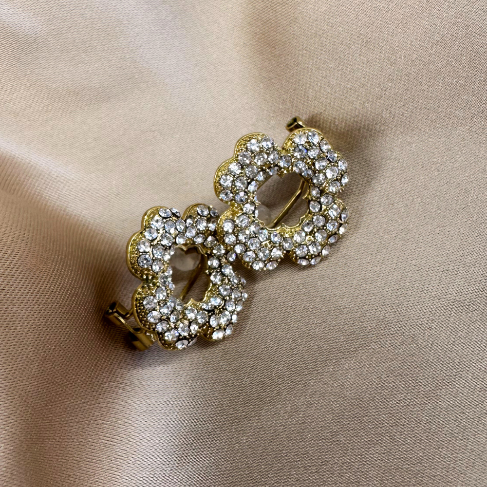 Close-up van de Bloom Studs oorbellen in bloemvorm, gevuld met zilveren stras steentjes, gemaakt van stainless steel, hypoallergeen, waterproof en verkleuren niet.