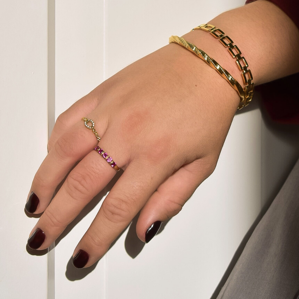 Een verstelbare gouden ring met delicate roze steentjes, gemaakt van hypoallergeen, waterproof en kleurvast stainless steel.