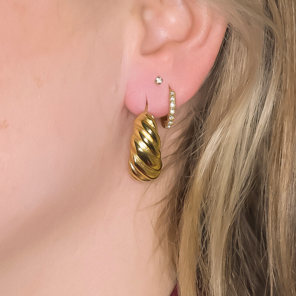 Close-up van de Shell Wave oorbellen, met een schelpachtige vorm en een subtiele werking erin, gemaakt van stainless steel, hypoallergeen, waterproof en verkleuren niet.