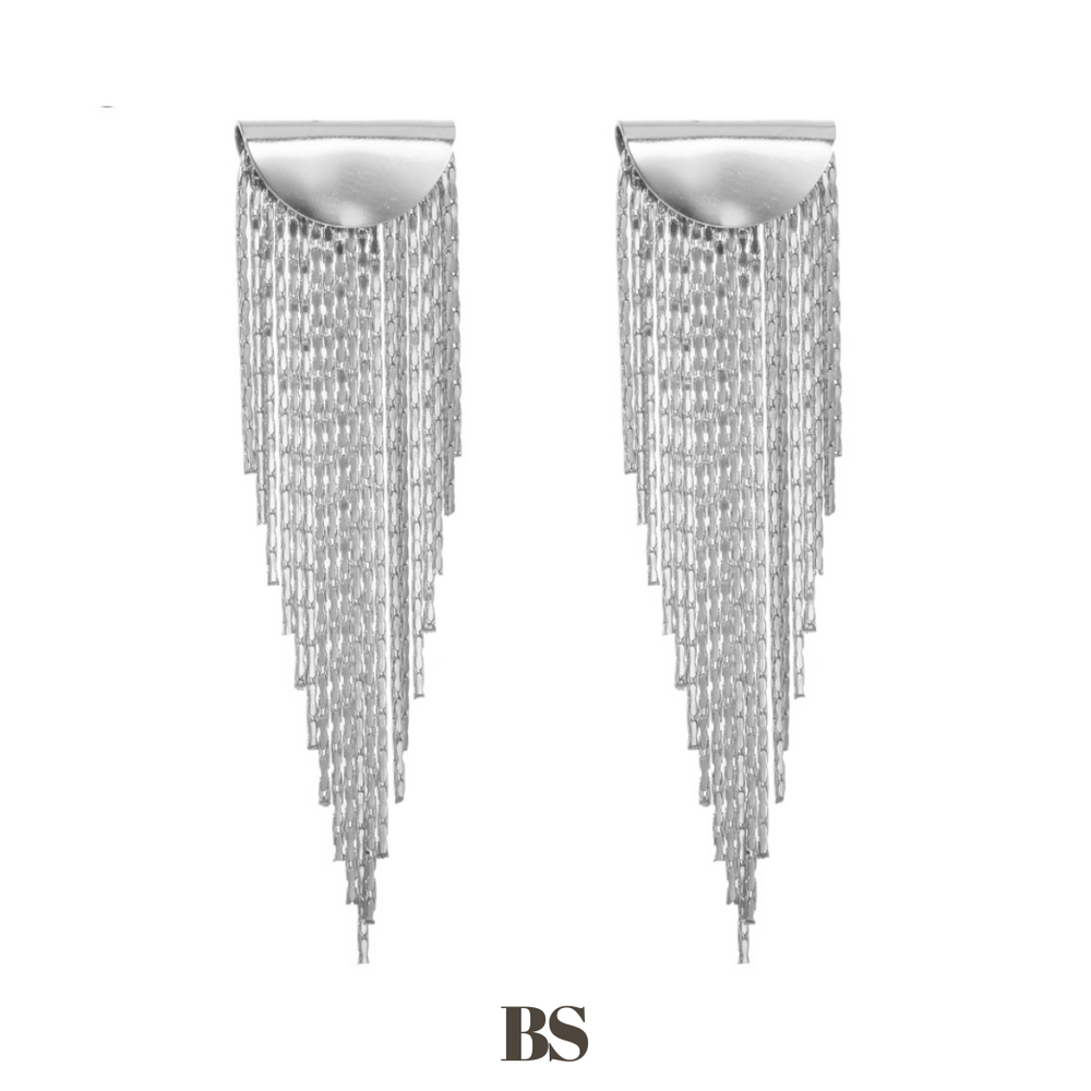 Close-up van de Golden Fringe oorbellen, met een gouden plaatje en lange franjes in verschillende lengtes die in een punt lopen, gemaakt van stainless steel, waterproof, hypoallergeen en verkleuren niet.