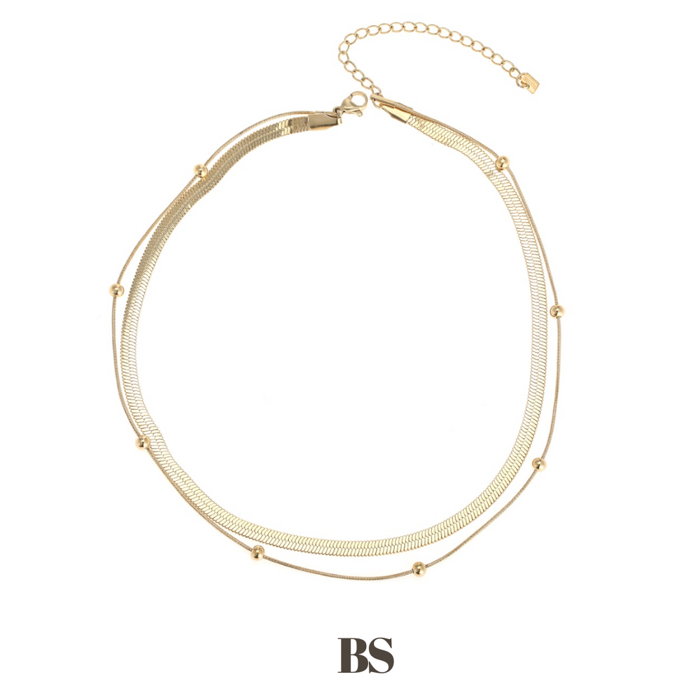 Close-up van de Faye ketting, bestaande uit twee lagen: een brede gouden ketting en een dunne gouden ketting met bolletjes, gemaakt van stainless steel, hypoallergeen, waterproof en verkleurt niet.