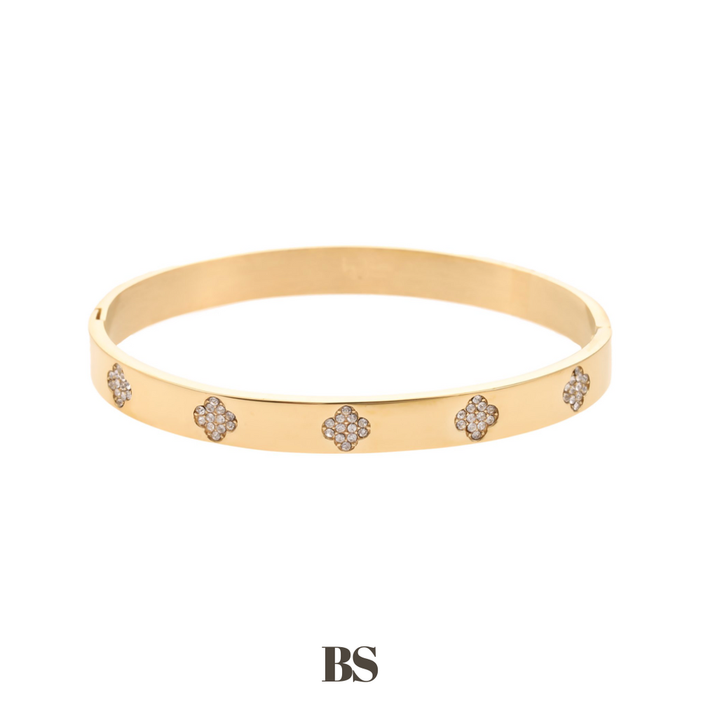 Close-up van de Golden Clover Bangle armband, met klavertjes vier gevuld met zilveren steentjes, gemaakt van stainless steel, hypoallergeen, waterproof en verkleurt niet.