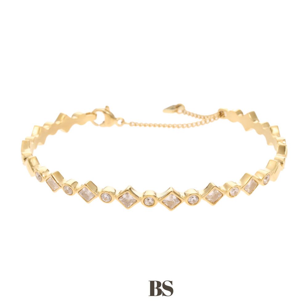 Productfoto van de gouden Macy armband, gemaakt van stainless steel met vierkante en ronde zilveren steentjes, glanzend en elegant om de pols gedragen.