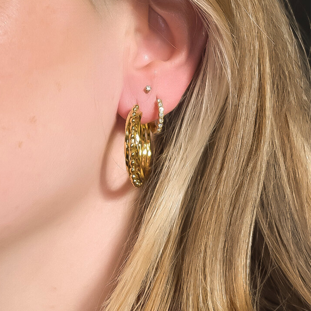 Close-up van de Vivian Ring oorbellen, met drie twisters en een band met kleine gouden rondjes, gemaakt van stainless steel, hypoallergeen, waterproof en verkleuren niet.