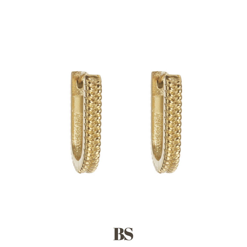 Close-up van de gold Zoë oorbellen in goud, met een subtiele werking in het ontwerp, gemaakt van stainless steel, hypoallergeen, waterproof en verkleuren niet.